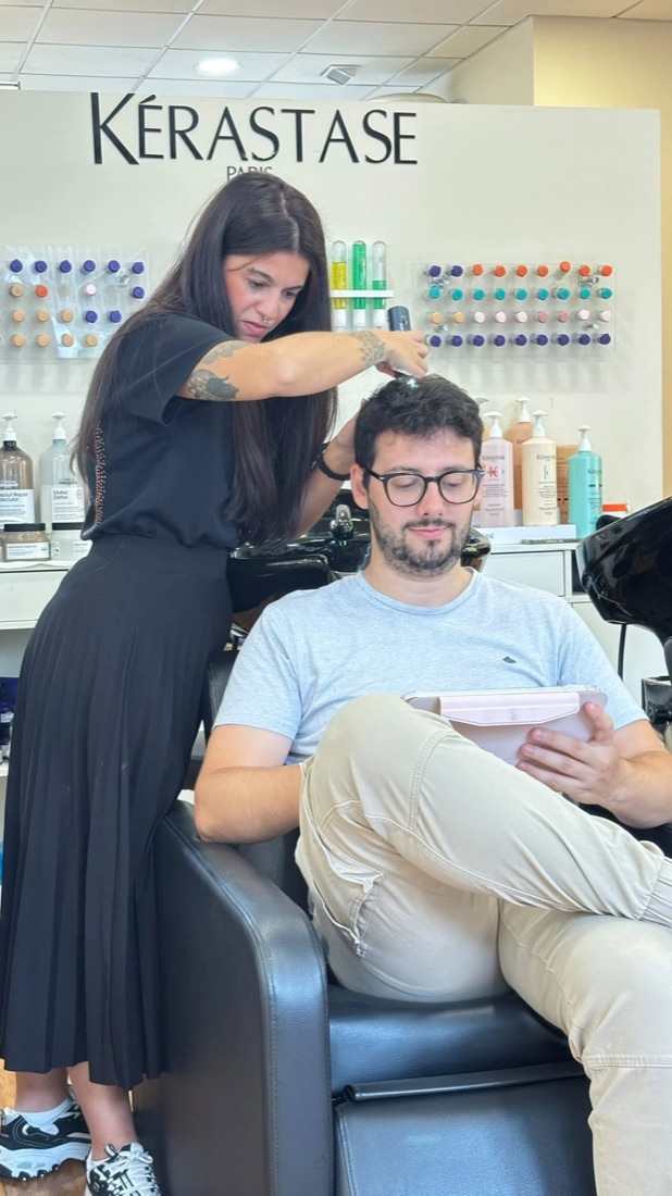 David Alonso en La Lola Hair Studio durante una sesión de contenido, frente a la pared de Kérastase